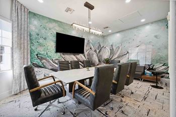 a meeting room with a large table and chairs and a large mural on the wall